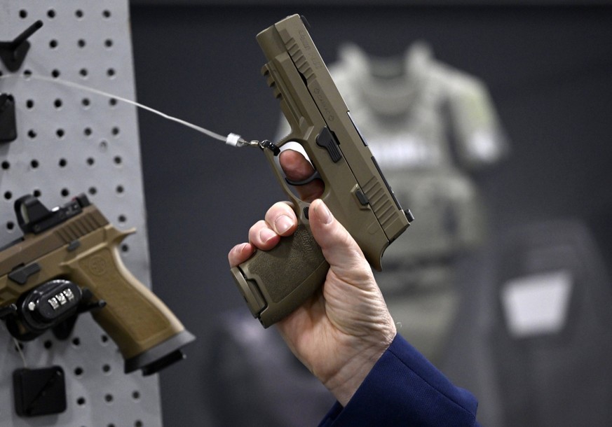 June 1, 2023, Ottawa, ON, CAN: An attendee takes in the look and feel of a SIG Sauer P320, also known as the C22, that will be the new pistol for the Canadian Forces, at the CANSEC trade show.