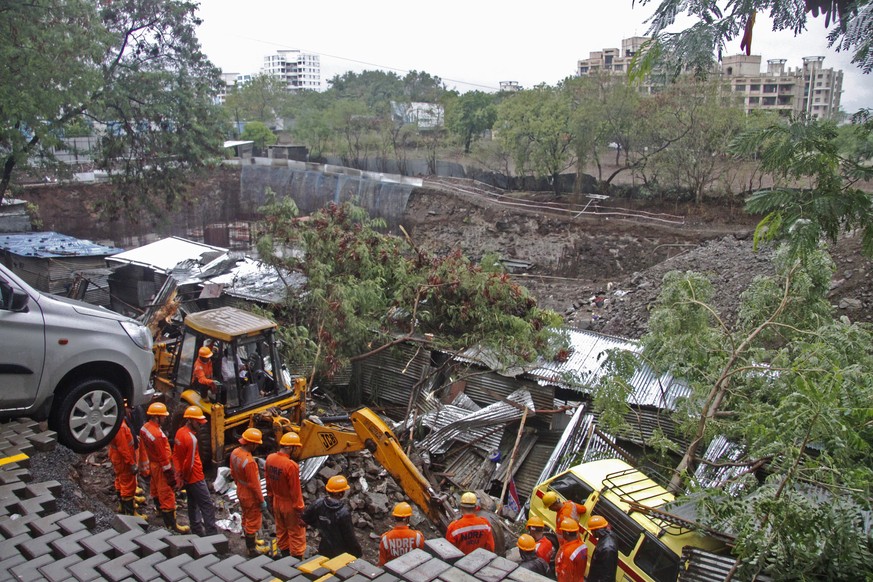 epa07681914 Members of the Indian National Disaster Response Force (NDRF) team works at the site of a wall collapse due to rain in Pune, India, 29 June 2019. According to media reports, more than a do ...