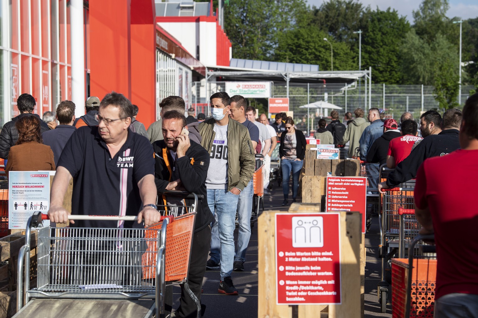 Kunden warten bei der Wiedereroeffnung vor dem Eingang des Bau- und Gartencenters Bauhaus, aufgenommen am Montag, 27. April 2020 in Schlieren. (KEYSTONE/Ennio Leanza)