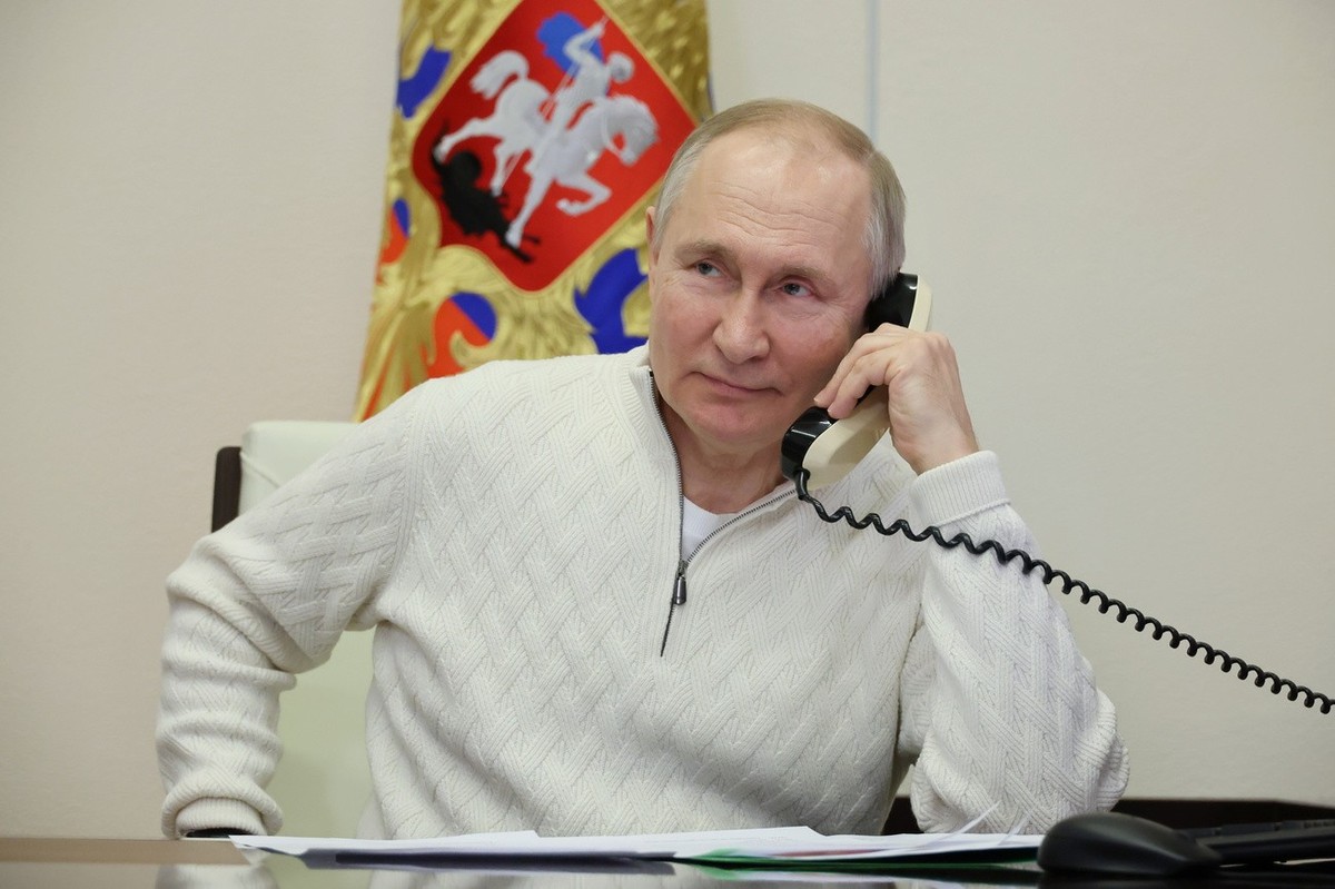 epa10391044 Russian President Vladimir Putin speaks on the phone to seven-year-old David Shmelev from Stavropol Krai region, who took part in the New Year Tree of Wishes nationwide charity campaign, a ...