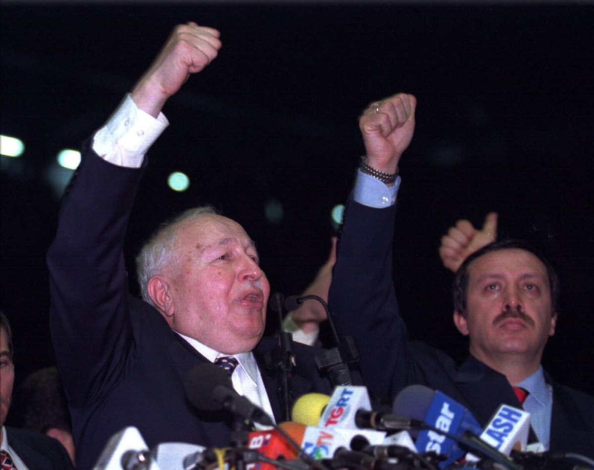 Turkey's former Prime Minister, leader of Islamic Welfare Party Necmettin Erbakan (left) and Mayor of Istanbul Recep Tayyip Erdogan salute the supporters with their party's symbol during Wel ...
