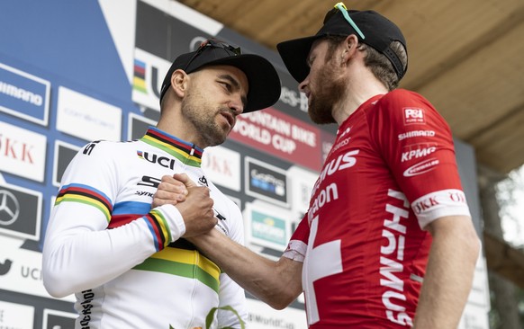 Nino Schurter, left, and Mathias Flueckiger of Switzerland react after crashing during the final lap at the UCI Cross Country Mountain Bike race, on Sunday, July 10, 2022, in Lenzerheide, Switzerland. ...