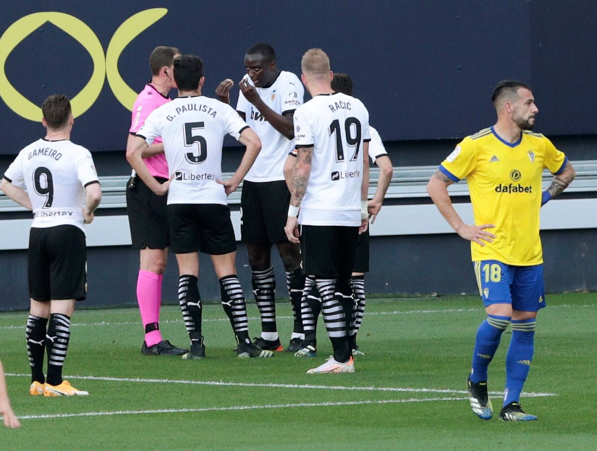 epa09115894 Valencia's French defender Mouctar Diakhaby (C) talks with referee David Medie Jimenez (2-L) after allegedly receiving a racist comment by Cadiz's defender Juan Cala (unseen) dur ...