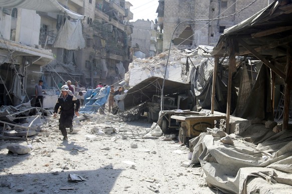 A civil defence member runs at a market hit by air strikes in Aleppo&#039;s rebel-held al-Fardous district, Syria October 12, 2016. REUTERS/Abdalrhman Ismail