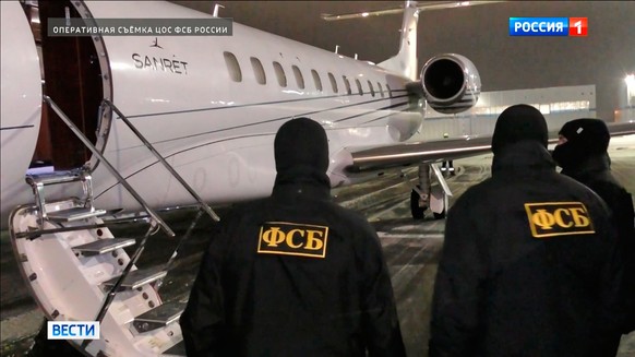 In this image made from video provided by Russian Federal Security Service via Russia-1 TV channel on Sunday, Feb. 8, 2026, Russian Federal Security Service agents stand at a plane waiting to escort a ...