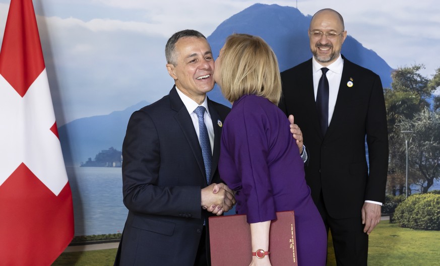 Swiss President Ignazio Cassis, left, welcomes British Foreign Secretary Liz Truss next to Ukrainian Prime Minister Denys Shmyhal during the Ukraine Recovery Conference URC, in Lugano, Switzerland, Mo ...