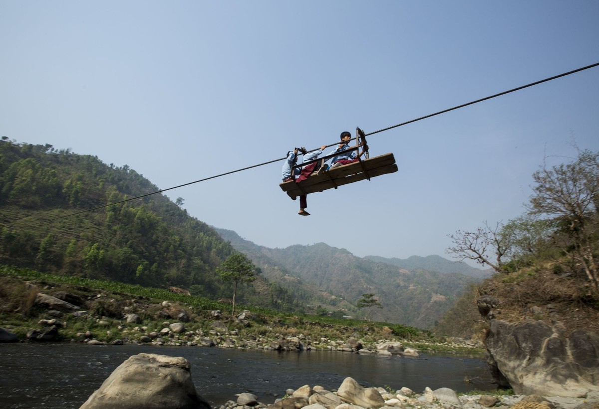 Schoolchildren Aasrang village of Chainpur village in Lalipur district , some 75 Kilometer south east from capital Kathmandu, making the risky crossing of the Bagmati River with the use of the Tuin (r ...