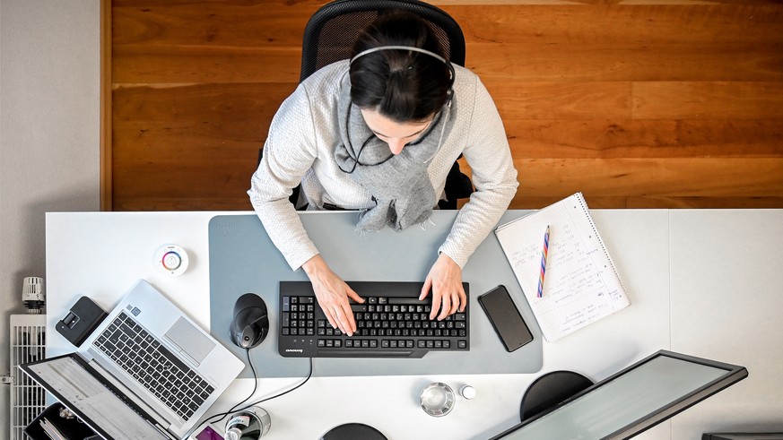 epaselect epa08933122 A woman with a headset sits in front of her computer in the study at home in Moenchengladbach, Germany, 12 January 2021. In view of the fact that the number of corona infections  ...