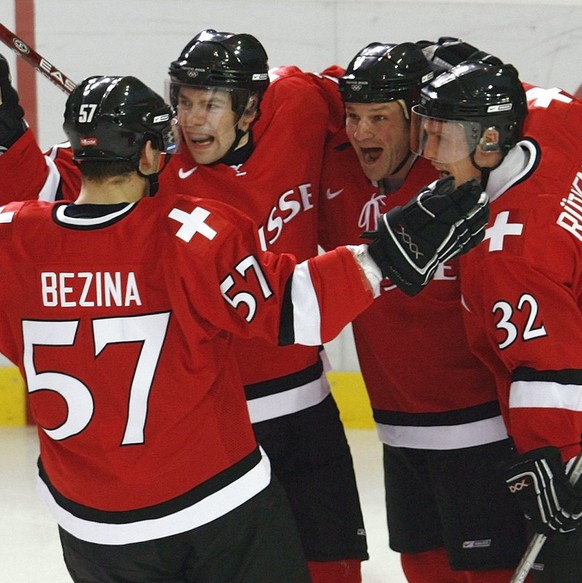 Swiss Goran Bezina, Martin Pluess, Paul di Pietro and Ivo Ruethemann, from left, celebrate di Pietros second goal, during their men's preliminary round group A ice hockey match Canada against Swi ...