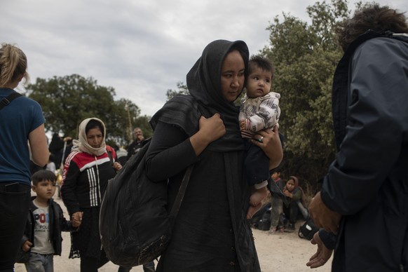 Afghan women with their children arrive with other migrants and refugees after crossing a part of the Aegean Sea, from Turkey to Greece on an overcrowded dinghy, near the town of Madamados on the Gree ...