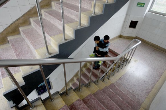 Xie Xu trägt seinen Freund Zhang Chi die Treppen hinunter.