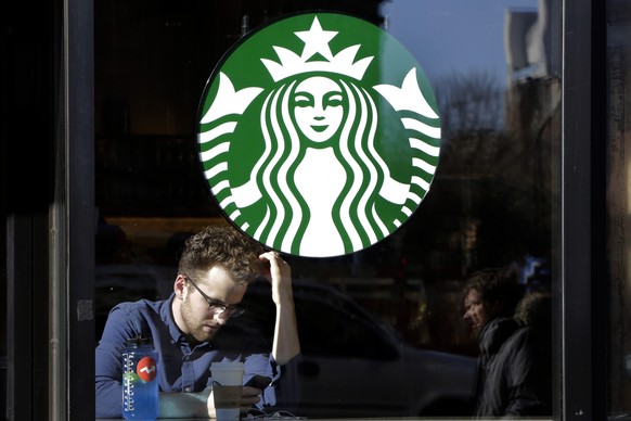 In this Monday, Jan. 11, 2016, photo, a man sits inside a Starbucks, in New York. Starbucks Corp. reports quarterly financial results, Thursday, Jan. 21, 2016. (AP Photo/Mark Lennihan)