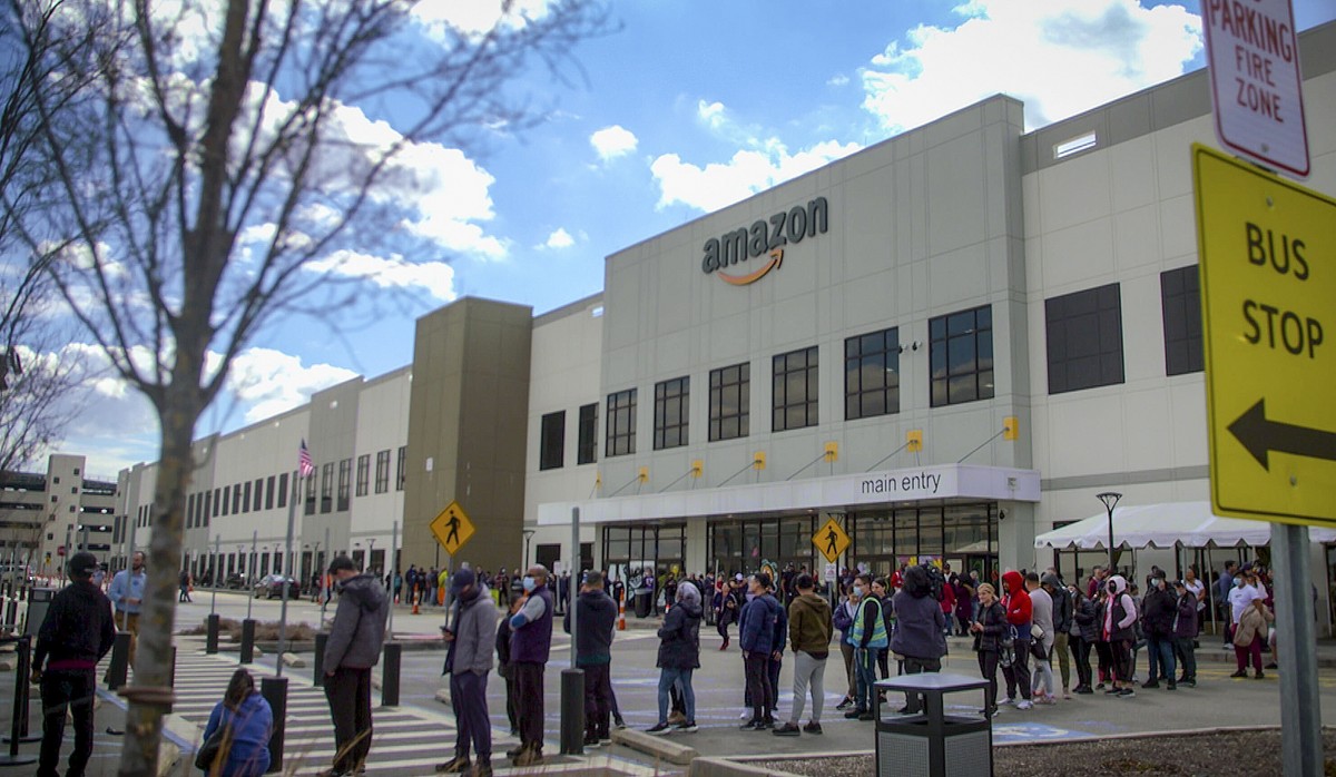 FILE - In this image from video, Amazon workers line up outside the company's Staten Island warehouse to vote on unionization, Friday, March 25, 2022, in New York. Amazon and the nascent group th ...