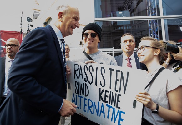 epa07811059 Brandenburg Premier and chairman of the Social Democratic Party (SPD) Dietmar Woidke (L) meets protesters with a cardboard reading &#039;Racists are no alternative&#039; outside a TV stati ...