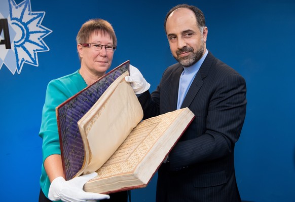 epa05434639 Petra Sandles (L), vice president of the Bavarian State Office of Criminal Investigations (LKA), hands a Quran from northern India (ca. 17th century) to Abdollah Nekounam Ghadiri, Consul G ...