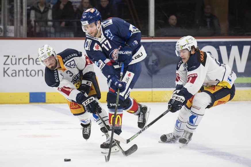 Zuercher Drew Shore, Mitte, spielt um den Puck gegen Zugs Nolan Diem, links, und Sven Senteler, rechts, im vierten Eishockey Playoff-Viertelfinalspiel der National League zwischen den ZSC Lions und de ...