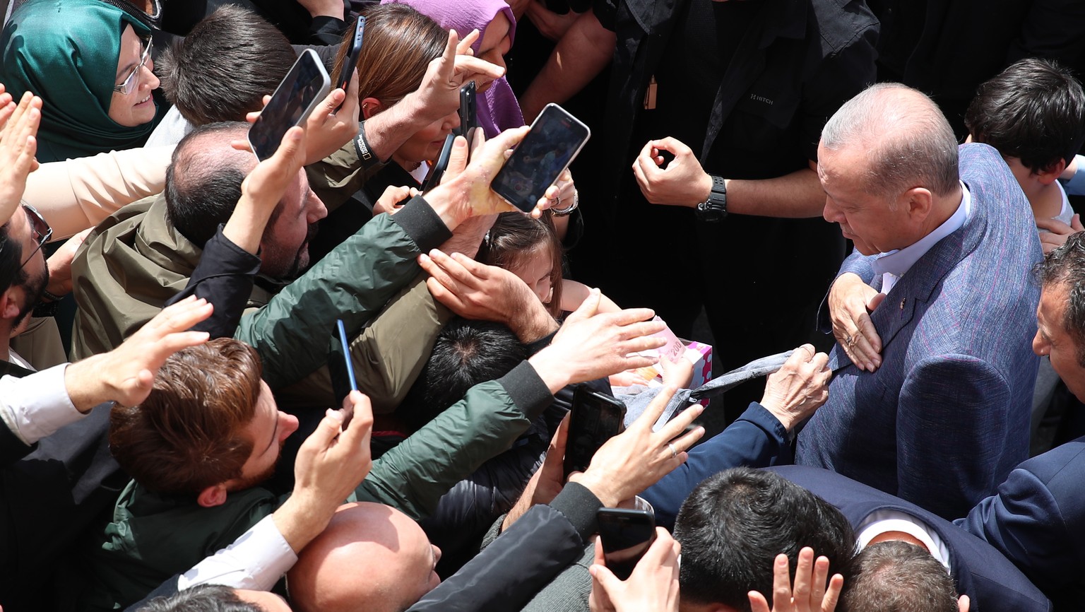 epaselect epa10626776 Turkish President Recep Tayyip Erdogan (R) greets to his supporters after casting his vote at a polling station in Istanbul, Turkey, 14 May 2023, as the country holds simultaneou ...