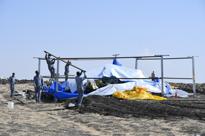 epa07434261 Rescue workers search the site for pieces of the wreckage of an Ethiopia Airlines Boeing 737 Max 8 aircraft near Bishoftu, Ethiopia, 13 March 2019. Ethiopian Airlines flight ET 302 carryin ...