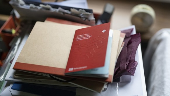 ***SYMBOLBILD/ MUSTER-PASS*** Ein neuer Schweizer Pass auf einem Stapel Unterlagen auf einem Tisch, fotografiert am Dienstag, 1. November 2022, in Bern. Seit dem 31. Oktober 2022 gibt es eine neue Pas ...