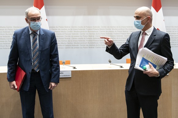 Bundespraesident Guy Parmelin, links, und Bundesrat Alain Berset sprechen an einer Medienkonferenz zu Covid 19 Massnahmen, am Mittwoch, 27. Januar 2021, in Bern. (KEYSTONE/Peter Schneider)