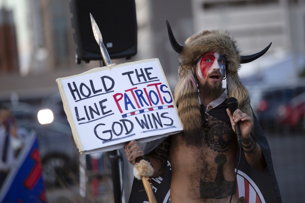 A Qanon believer speaks to a crowd of President Donald Trump supporters outside of the Maricopa County Recorder's Office where votes in the general election are being counted, in Phoenix, Thursda ...