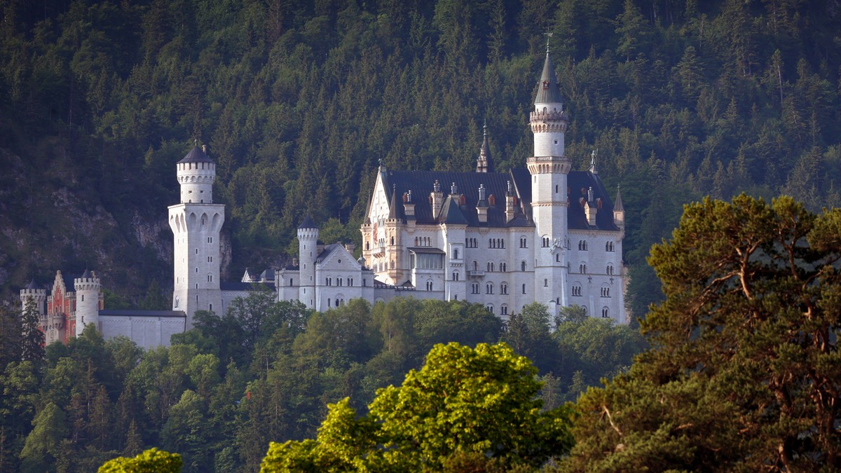 18.06.2023, Bayern, Schwangau: Das Schloss Neuschwanstein im Morgenlicht. Bei einem B