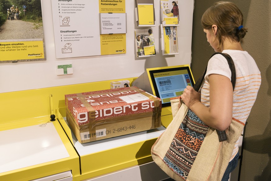 ZUR NEUAUSRICHTUNG DER POST STELLEN WIR IHNEN HEUTE, DONNERSTAG, 29. JUNI 2017, FOLGENDES NEUES BILDMATERIAL ZU POSTAGENTUREN AUS STADT, LAND UND AGGLOMERATION ZUR VERFUEGUNG --- A customer places a p ...