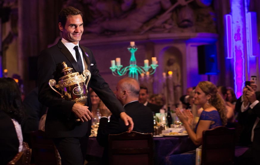 epa06092343 A handout photo made available by the AELTC showing Roger Federer of Swizerland arriving with the men&#039;s singles wimbledon trophy at the Championships Dinner at the Guildhall, London,  ...