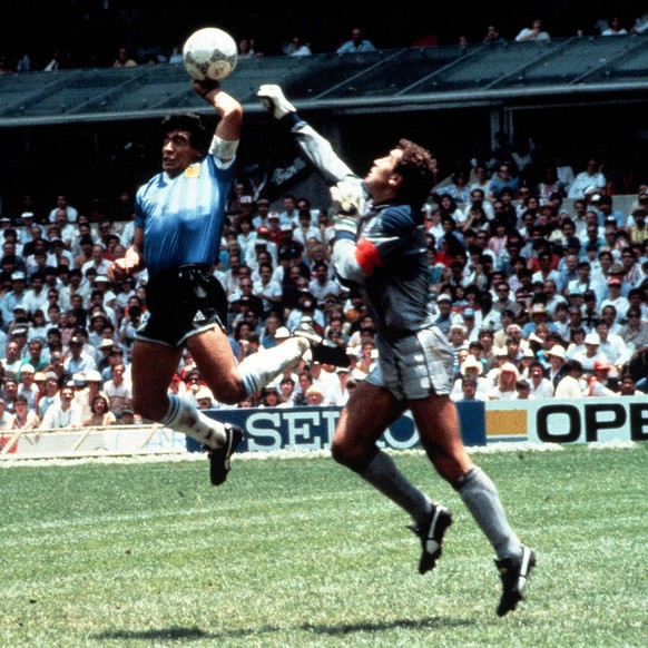 Eine beruehmte und vieldiskutierte Szene der Fussball-WM-Geschichte vom 22. Juni 1986 mit Tatort Aztekenstadion in Mexiko-Stadt: Die argentinische Fussball-Legende Diego Maradona (M) boxt in der 51. M ...