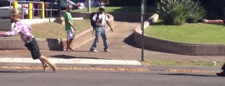 Unbeteiligte schauen zu, wie Hawkes getroffen zu Boden stürzt.