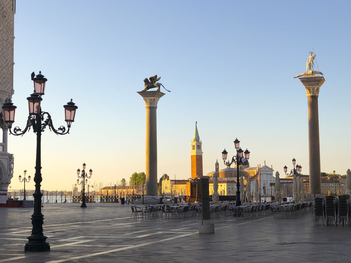 Sculpture of Sacred Teodor - the first patron of Venice standing on a dragon won by it and sculpture of the vebetian lion with wings on Piazza San Marco, Venice, Italy