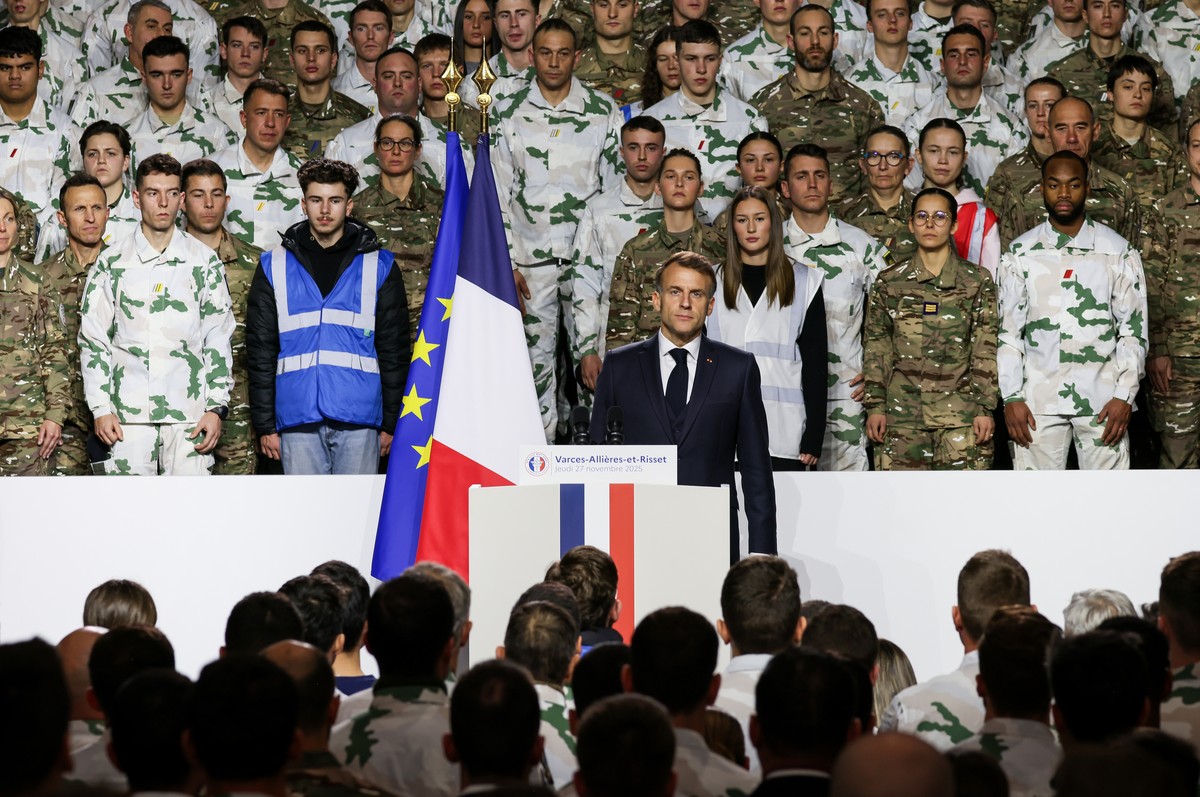 France's President Emmanuel Macron shows his respect to the national anthem after he unveiled a new national military service at the military base in Varces, French Alps, Thursday, Nov. 27, 2025. ...