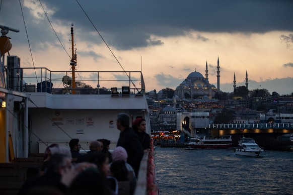 November 14, 2025, Istanbul, Turkey: Passengers on the terrace of a city lines ferry are seen with the Suleymaniye Mosque in the background at sunset in Istanbul. Istanbul Turkey - ZUMAs197 20251114_a ...