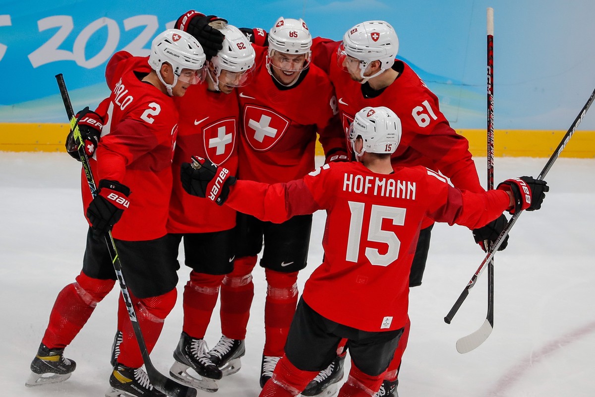epa09758237 Denis Malgin (2-L) of Switzerland celebrates with teammates after scoring during the Men's Ice Hockey Qualification Play-off match between Czech Republic and Switzerland at the Beijin ...