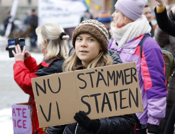 FILE - Climate activist Greta Thunberg attends a demonstration by youth-led organization Aurora, in Stockholm, Sweden, Friday, Nov. 25, 2022. Writing on cardboard reads in Swedish &quot;Now we sue the ...