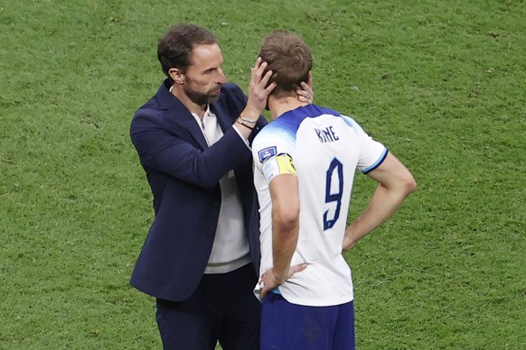 epa10360395 Head coach Gareth Southgate of England. consoles his player Harry Kane (R) after the FIFA World Cup 2022 quarter final soccer match between England and France at Al Bayt Stadium in Al Khor ...