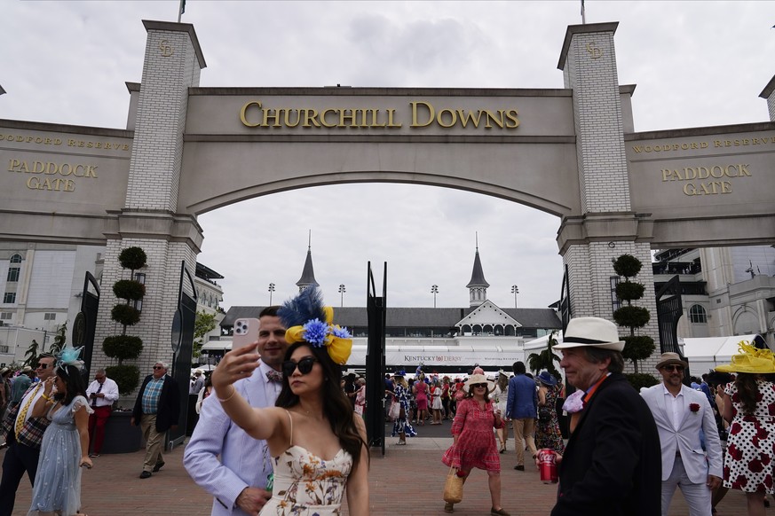 People walk on the grounds of Churchill Downs for the 149th running of the Kentucky Derby horse race on Saturday, May 6, 2023 in Louisville, Ky.  (AP Photo/Brynn Anderson)
