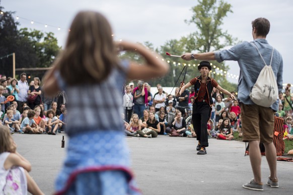 Besucher des Theaterspektakels verfolgen die Vorfuehrung eines Strassenkuenstlers am Freitag, 19. August 2016 auf der Landiwiese in Zuerich. Das Zuercher Theater Spektakel dauert vom 18. August bis zu ...