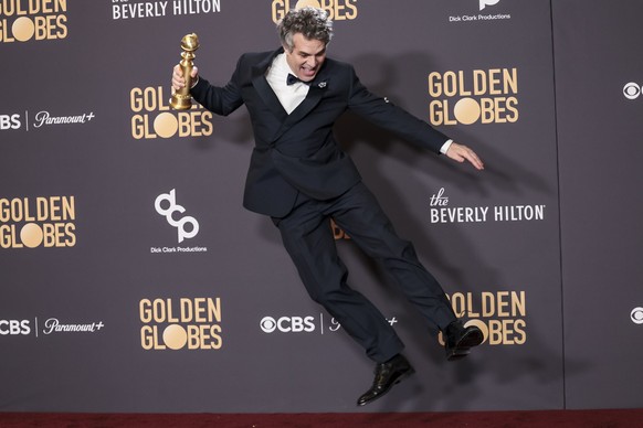 epa11063679 US actor Mark Ruffalo jumps while holding a Golden Globe award for the movie &#039;Poor Things&#039; in the press room during the 81st annual Golden Globe Awards ceremony at the Beverly Hi ...