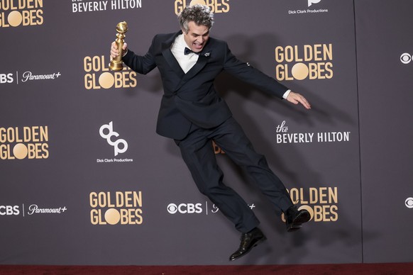 epa11063679 American actor Mark Ruffalo jumps while holding a Golden Globe award for the film 'Poor Things' in the press room during the 81st annual Golden Globe Awards ceremony at the Beverly Hi...