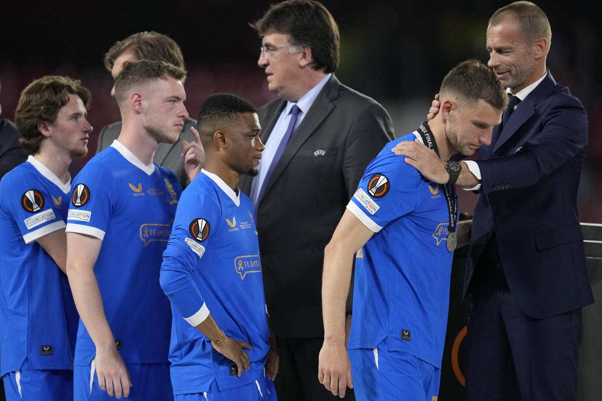 UEFA President Aleksander Ceferin, right, hands a second place medal to Rangers' Borna Barisic after the Europa League final soccer match between Eintracht Frankfurt and Rangers FC at the Ramon S ...
