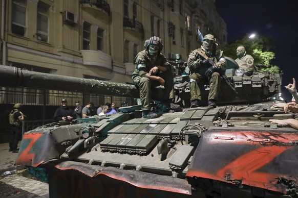 Members of the Wagner Group military company sit atop a tank on a street in Rostov-on-Don, Russia, Saturday, June 24, 2023, before leaving an area near the headquarters of the southern military district.