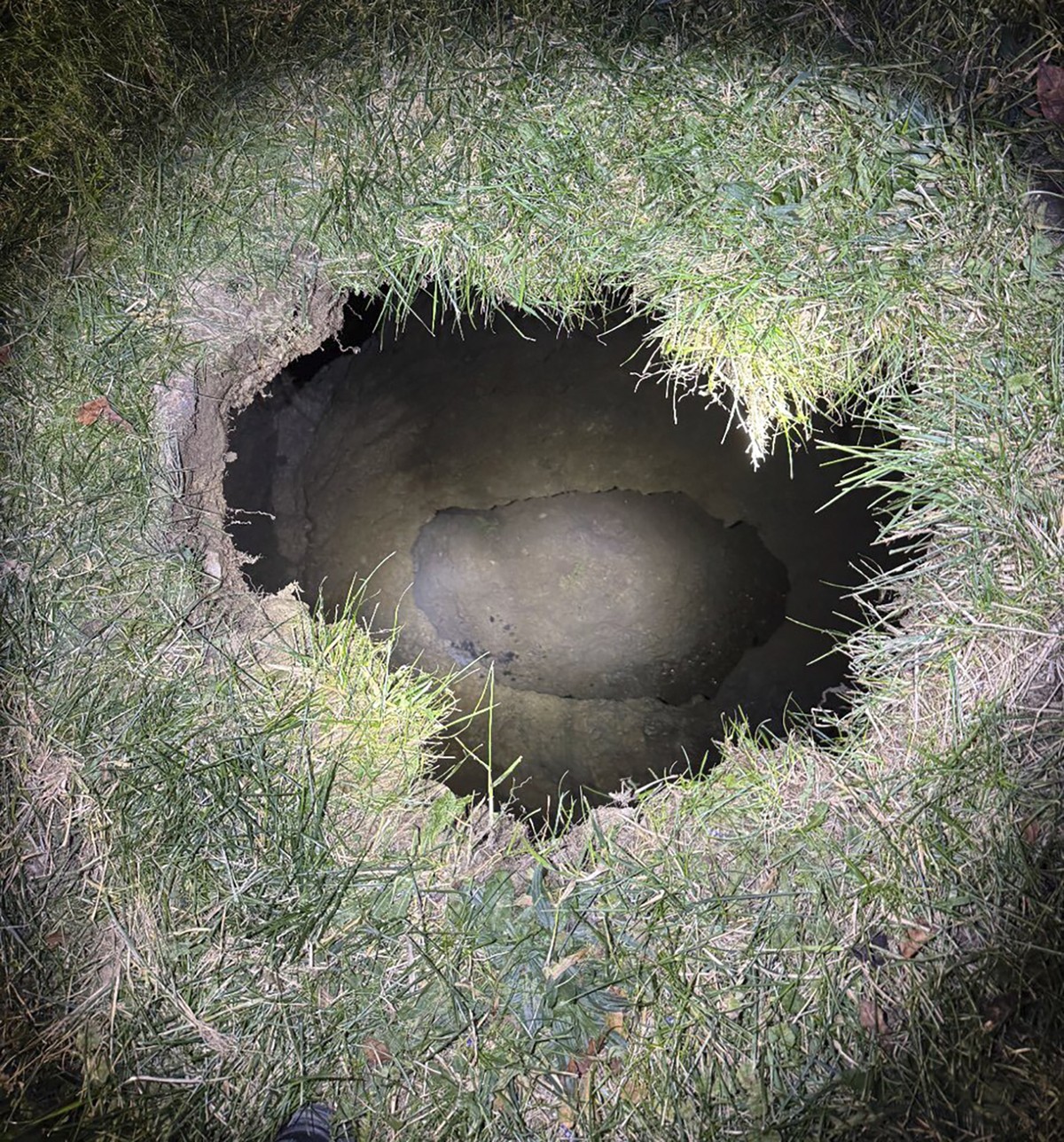 This Tuesday, Dec. 3, 2024. image provided by the Pennsylvania State Police shows the top of a sinkhole in the village of Marguerite, Pa., where rescuers were searching for a woman who disappeared. (P ...