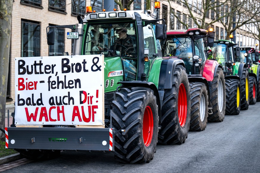 08.01.2024, Bremen: Zahlreiche Traktoren stehen in der Bremer �berseestadt bei einer Demonstration von Bauern. Auf einem Schild ist dabei die Aufschrift �Butter, Brot &amp; Bier - fehlen bald auch Dir ...