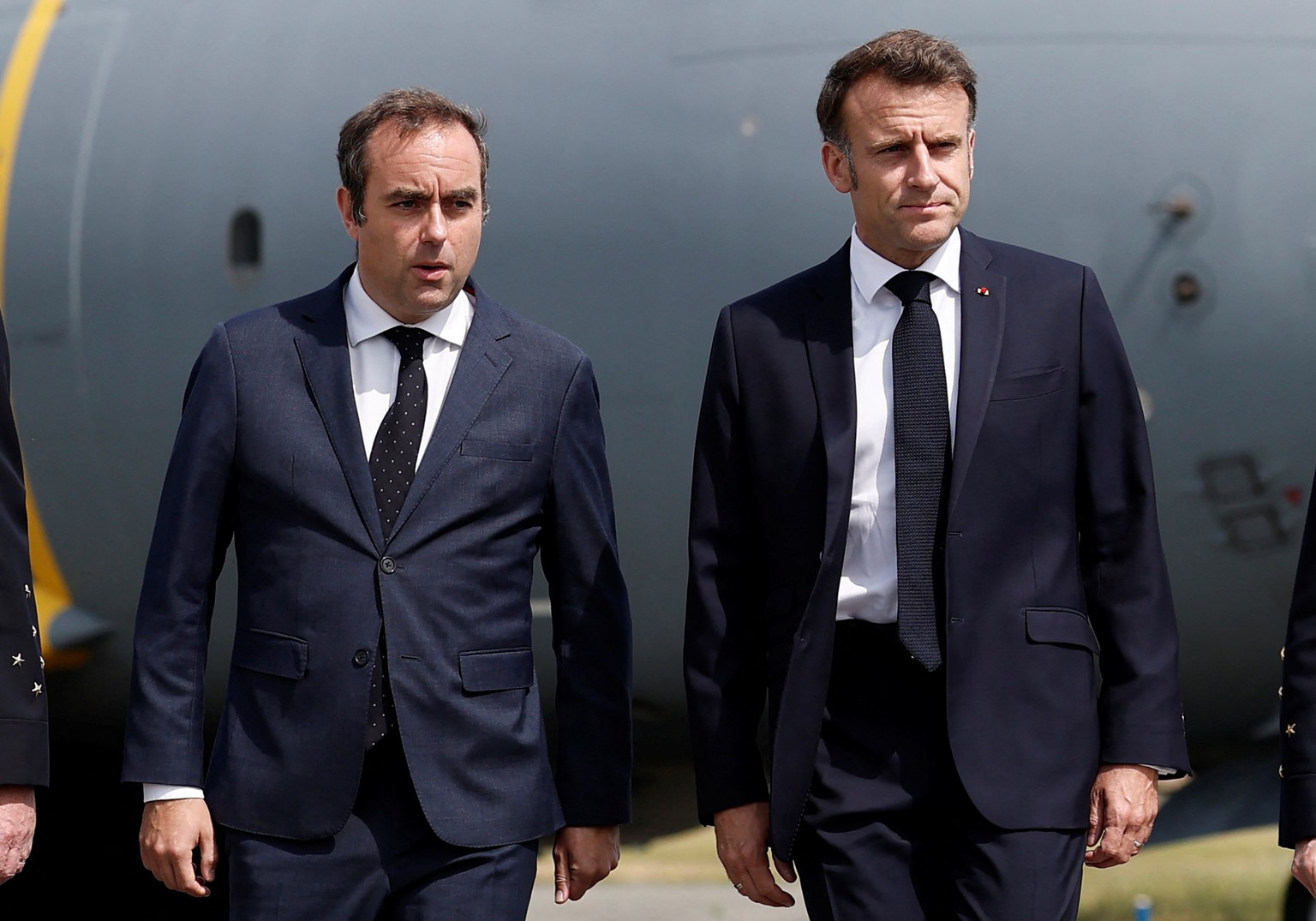 epa12187078 French President Emmanuel Macron (R), welcomed by French Minister of Armed Forces Sebastien Lecornu, walks on the tarmac after disembarking from an Airbus A400M military plane for a visit  ...