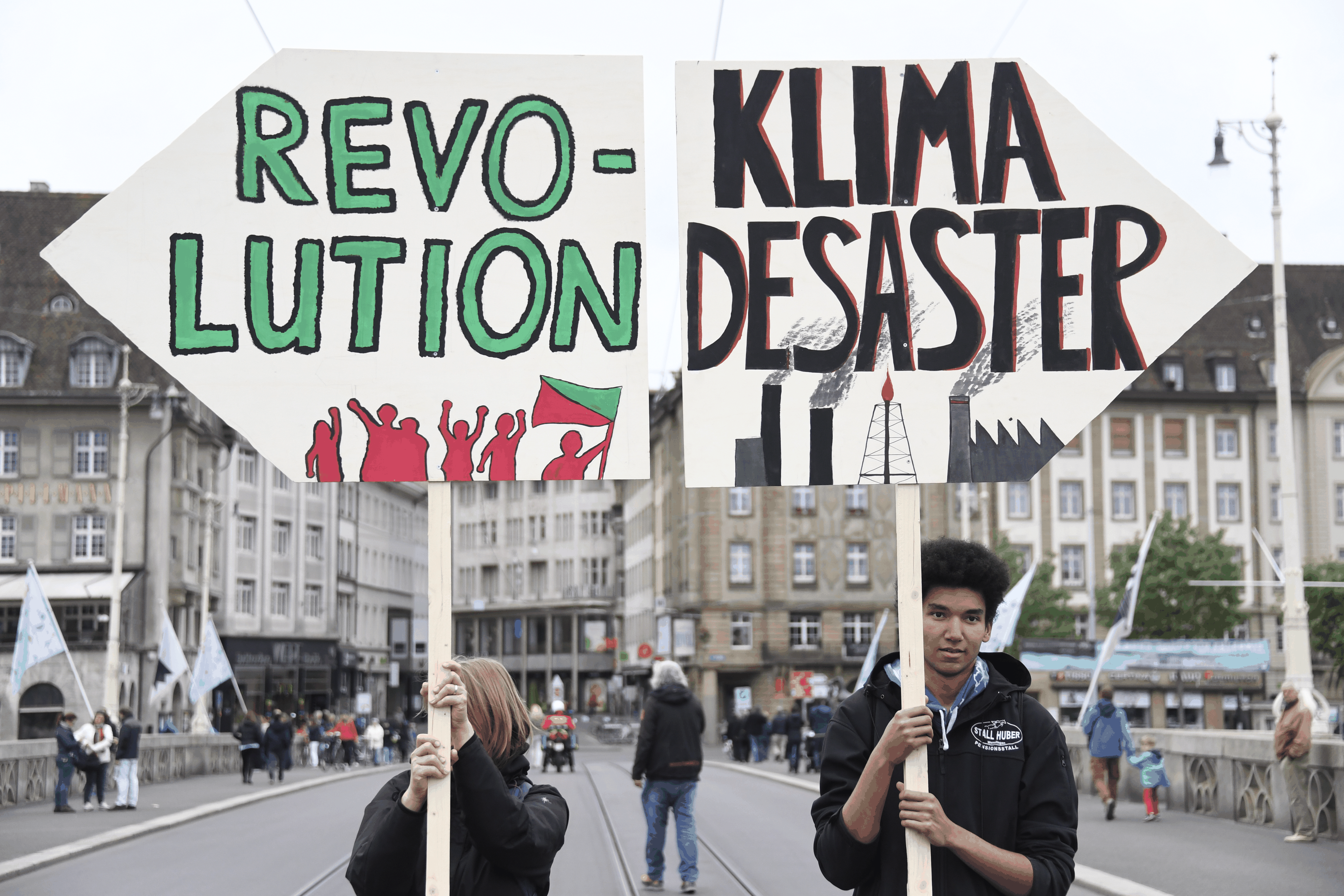 Zwei Demonstranten halten Tafeln mit der Aufschrift &quot;Revolution&quot; und &quot;Klima Desaster&quot;, wahrend des Demonstrationsumzug am Dienstag, 1. Mai 2018, am Tag der Arbeit. (KEYSTONE/Georgi ...