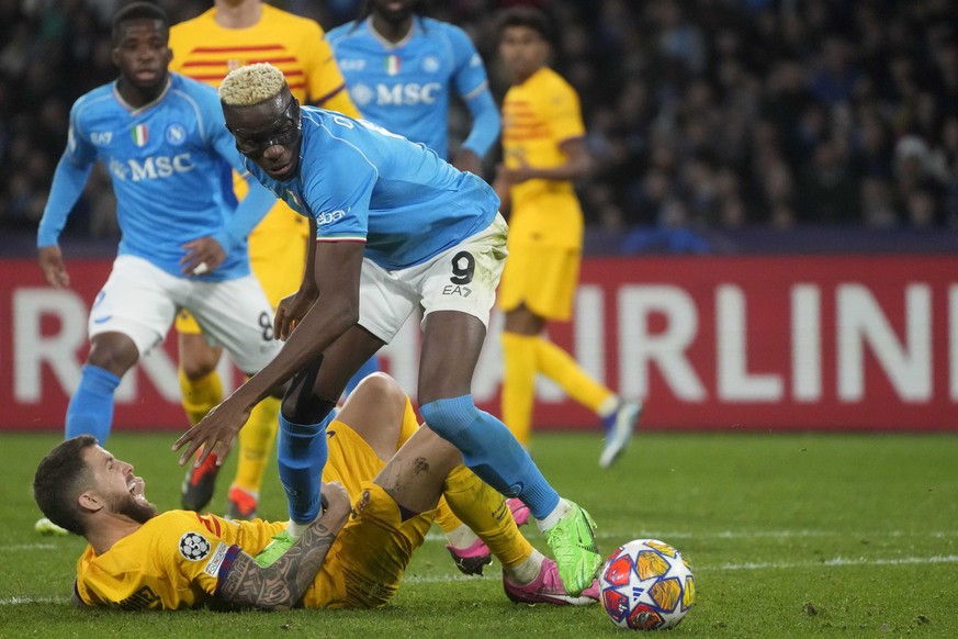 Napoli&#039;s Victor Osimhen, top, and Barcelona&#039;s Inigo Martinez, bottom, challenge for the ball during the Champions League, round of 16, first leg soccer match between SSC Napoli and FC Barcel ...