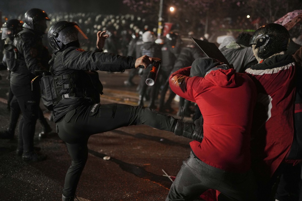 A riot police officer kicks a protester as they clash during a protest after Istanbul's Mayor Ekrem Imamoglu was arrested and sent to prison, in Istanbul, Turkey, Sunday, March 23, 2025. (AP Phot ...