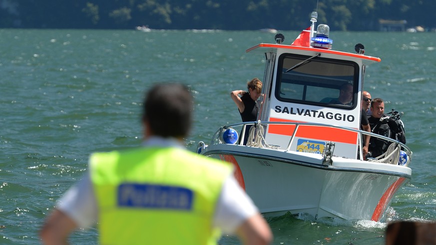 Ein Polizist steht am Ungluecksort am Luganersee bei Lugano am Donnerstag, 31. July 2014. Am fruehen Donnerstagnachmittag ist ein Mann im Luganersees ertrunken. Der 33-Jaehrige hatte sich mit acht Fre ...