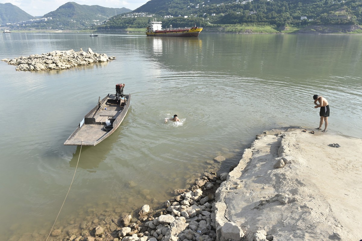 Residents cool off along the Yangtze River in Yunyang county in southwest China's Chongqing Municipality Tuesday, Aug. 16, 2022. Unusually high temperatures and a prolonged drought are affecting  ...